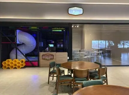 Mesas do salão de festas com vista para a área dos brinquedos
